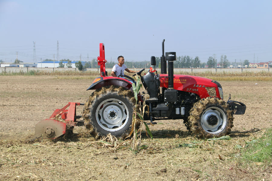 一台大型秸秆还田机正对收获的玉米秸秆实施粉碎还田作业